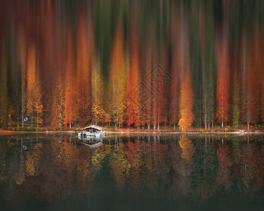 左右镜像效果充满色彩的秋天森林运动模糊的艺术效果反映在阿尔普西湖的水里背景