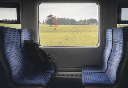穿梭于德国地区列车的概念图象中车内有蓝色椅子行李和窗边的秋天风景图片