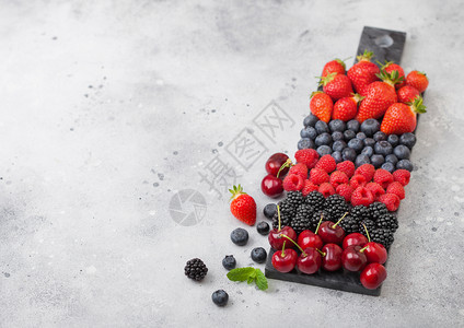 黑大理石板上的浅厨房桌底有草莓蓝黑和樱桃图片
