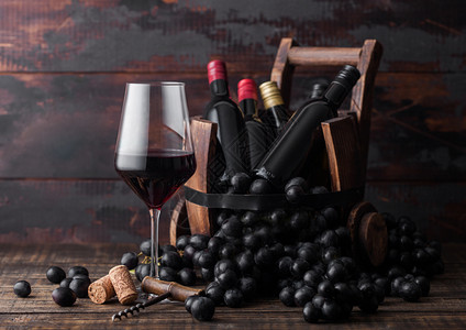 黑色的葡萄酒和古老木桶里小酒瓶深黑木质背景红酒保留生命的概念图片