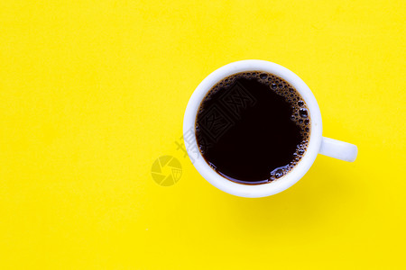 黄色背景的热黑咖啡顶视图图片