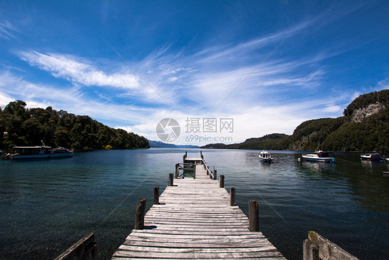 湖边一个空木头码的视图蓝天空在背景上图片