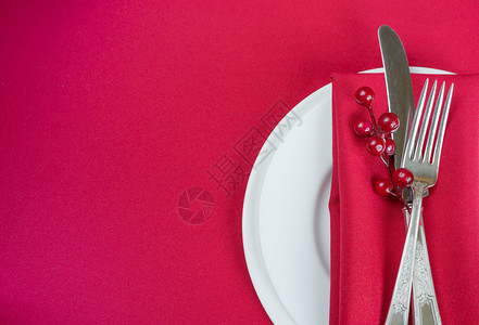 白瓷板上有刀和叉子红色纸巾薄和胡椒浆白瓷板位于一张上面有红色桌布的子上有文字空间背景图片