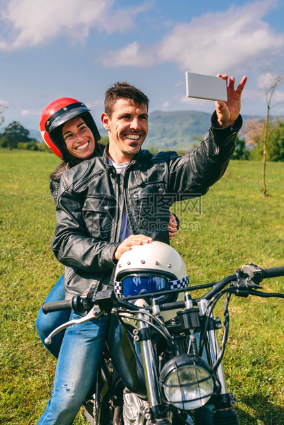 年轻夫妇在摩托车室外自拍夫妇在摩托车上自拍图片