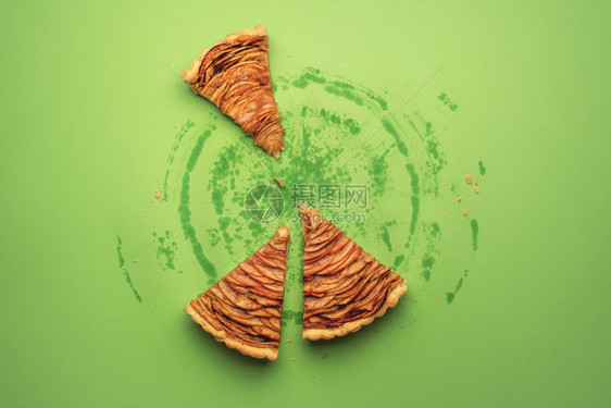 三块苹果派和油脂印在绿纸背景上从整个馅饼图片