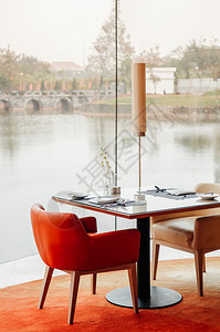 2014年7月日febdaltvienam现代生机勃的橙色手椅和酒店餐厅的晚桌图片