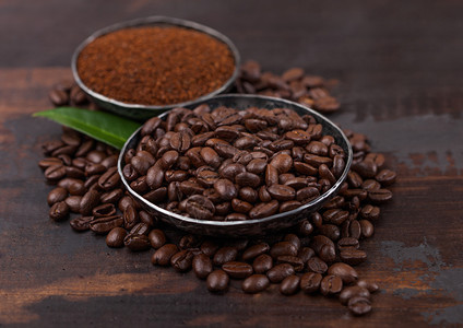 新鲜有机生咖啡豆配有粉末和木头咖啡树叶图片