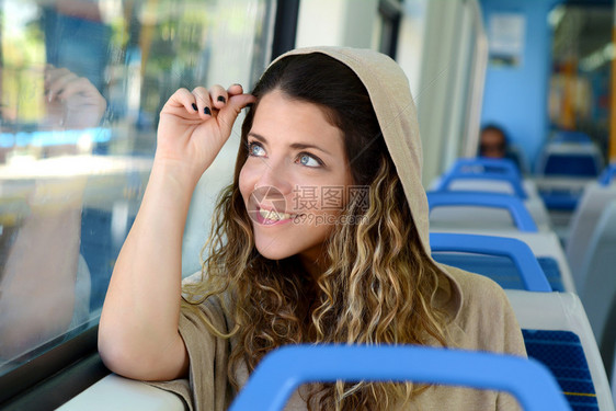 城市年轻女在火车上透过窗户看现代人的生活方式图片