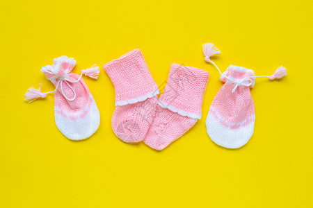 黄色背景的婴儿手套和袜子图片