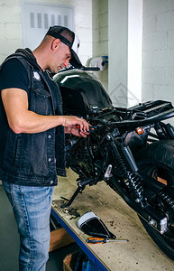 技工在车间更换保险丝修理定做的摩托车摩托车修理工换保险丝图片