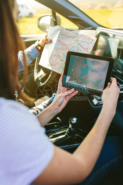夫妇比较纸面和汽车平板上的GPS导航仪夫妇比较纸面和GPS导航仪图片