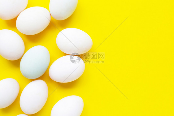 黄色背景的白蛋顶视图图片