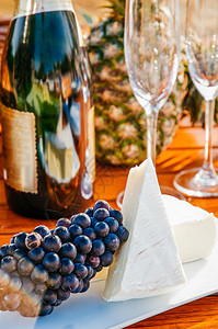 红葡萄和块的面包芝士和香槟瓶玻璃图片