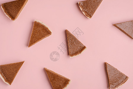 感谢面包店商品背景南瓜派切片随机出现在粉红色纸面背景上平坦的馅饼秋天蛋糕模式图片
