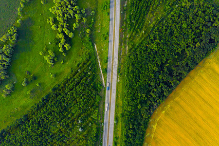 穿越绿色和黄夏季田地的高速公路空中航向图片