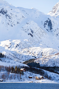 传统的挪威木屋站在湖边和远处的山上荒岛北边图片