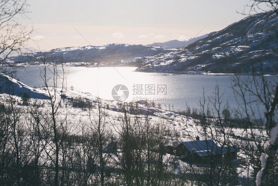 美丽的景观传统挪威木屋站在湖边和远处的山上图片