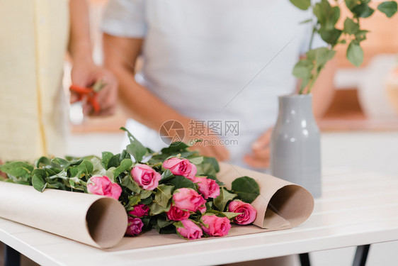 在家的木桌子上做花束的夫妇图片