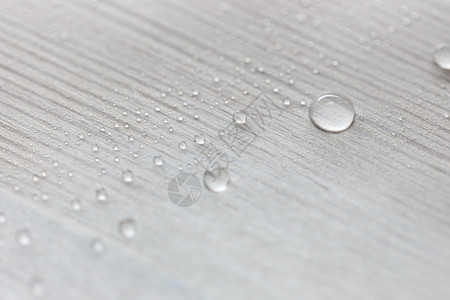 白木板表面的水滴由用蜡遮盖的油层所制成背景图片