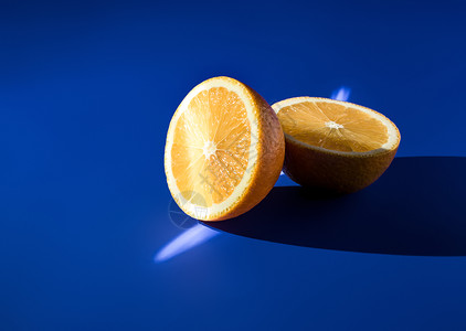 蓝口在阳光明亮的蓝背景上红橙子的两半背景