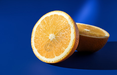 在阳光明亮的蓝背景上红橙子的两半图片
