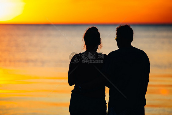 美丽的海景人们看着面的日落图片