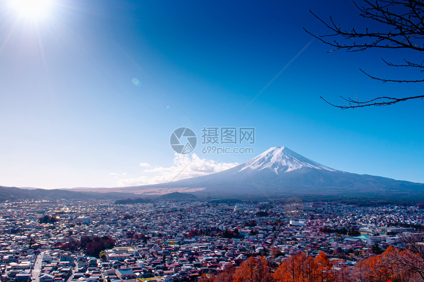 在河口谷附近的fujiyoshda公园中看到有雪和蓝天太阳耀斑的fuji山有彩色秋树和香木的Shimoysda城市在川口果附近的图片