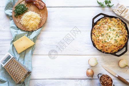白桌上的洋葱和培根配有料的意大利奶酪面图片