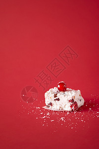 一块澳洲的xma甜点用椰子和干果自制红色背景图片