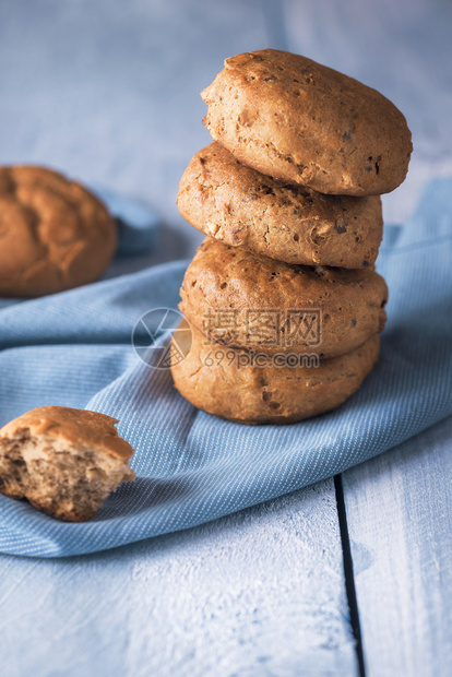 面包新鲜烘烤堆在蓝毛巾上面包卷由黑麦和坚果制成早餐热面包土制健康面包图片