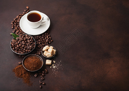 白杯新鲜生有机咖啡豆子和土粉甘蔗糖立方体深底有咖啡树叶图片