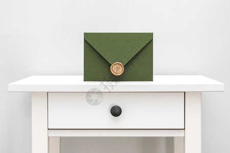 绿色信封带有设计纸板和白色桌子背景的封条绿色信带有设计师纸板和白色背景的封条图片