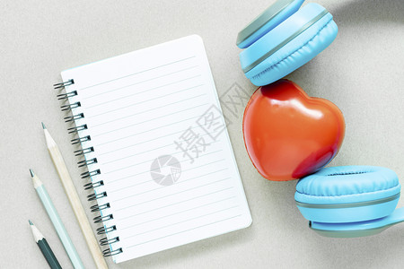 白纸笔记本用铅和红心耳机在白桌上空开的页面图片