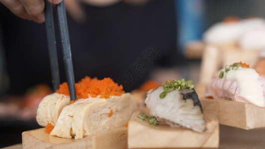 在日本餐厅拿着筷子吃寿司的女人图片