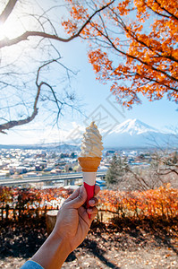 与Fuji山的软奶油冰淇淋锥和在Arakuymseng公园的多彩秋木树背景Fujiyoshda图片