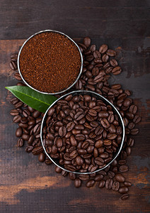 新鲜有机生咖啡豆配有粉末和木头咖啡树叶图片