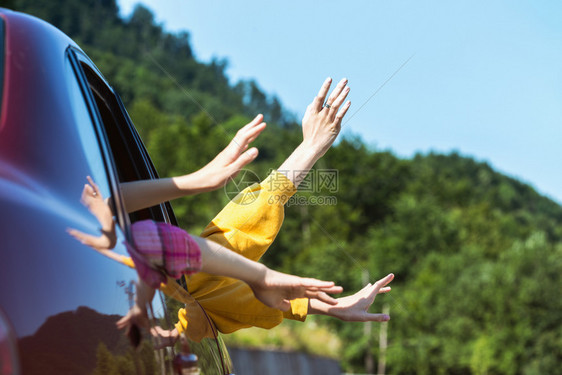 男人和孩子的手从车窗旁看着山地背景夏季公路之旅图片