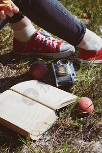 女孩野餐脚穿运动鞋书桃子和架反光摄影机图片