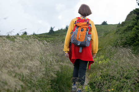 观光女游客正在山上走小路图片