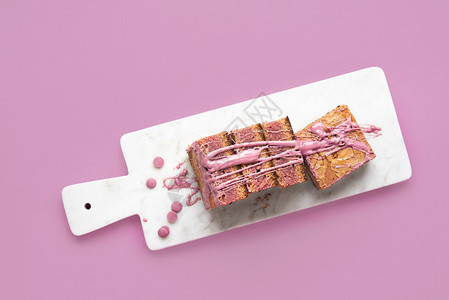 红宝石巧克力甜点在白色切削板和粉红背景上展示切片在粉红色巧克力蛋糕上方图片