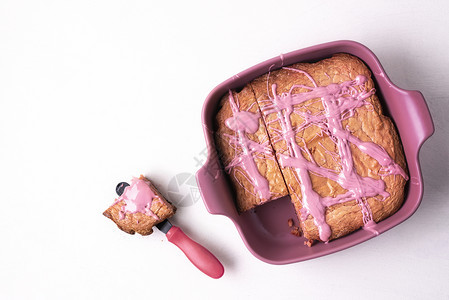 盘子里的粉红褐色蛋糕和白桌上的部分红宝石巧克力甜点上面的红宝石粉甜点平整的色甜点美味的粉红色巧克力食品图片