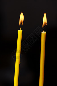 在黑色背景上点燃蜡烛光的火焰图片