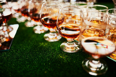 吧台上放着一杯白兰地威士忌一大杯白兰地酒杯里有酒精吧台上摆放着各种酒精饮料吧台上有白兰地的玻璃杯图片