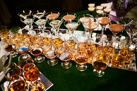 酒杯里有酒精吧台上摆放着各种酒精饮料吧台上有白兰地的玻璃杯背景