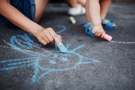 女孩在人行道上画着粉笔小孩在人行道上画着粉笔小女孩在人行道上画着粉笔图片
