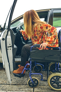 坐在轮椅上的年轻女士准备上残疾人专属汽车图片
