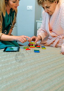 向老年痴呆症女病人展示几何形状游戏的女医生向老年病人展示几何形状的女医生图片