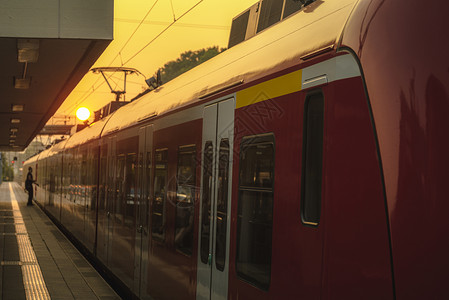 红色列车和现代站台平后面的太阳图片