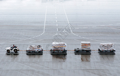 在停机坪国际机场的行李拖车上工作背景图片