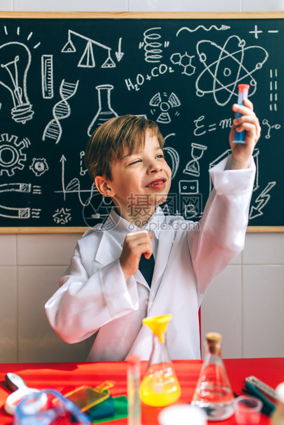 男孩打扮成化学家看着测试管玩化学游戏在黑板前玩化学游戏画图片